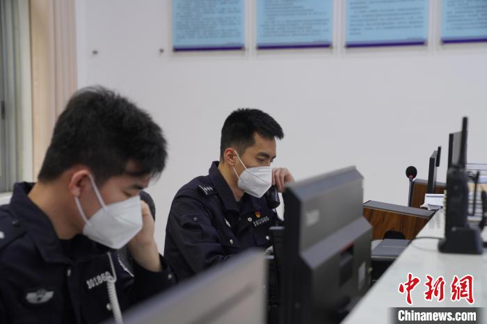 圖為民警黃昊與同事一同接聽報警電話?！⊥鯓s鑫 攝