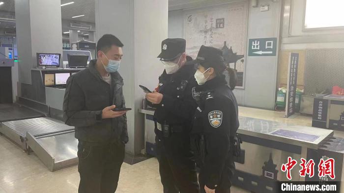 民警劉學強和李晨俊正在與旅客進行交流。　李小朋 攝