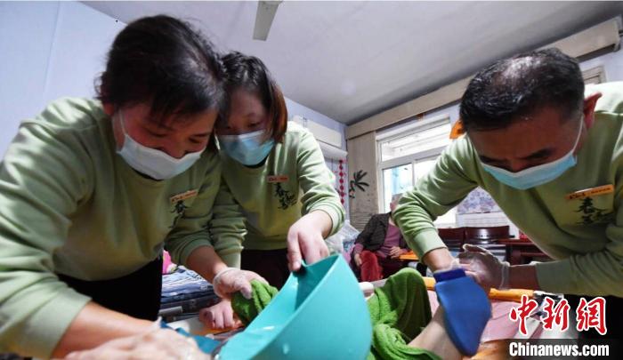 張慧和同事一起為老人進(jìn)行助浴服務(wù)?！∈茉L者供圖