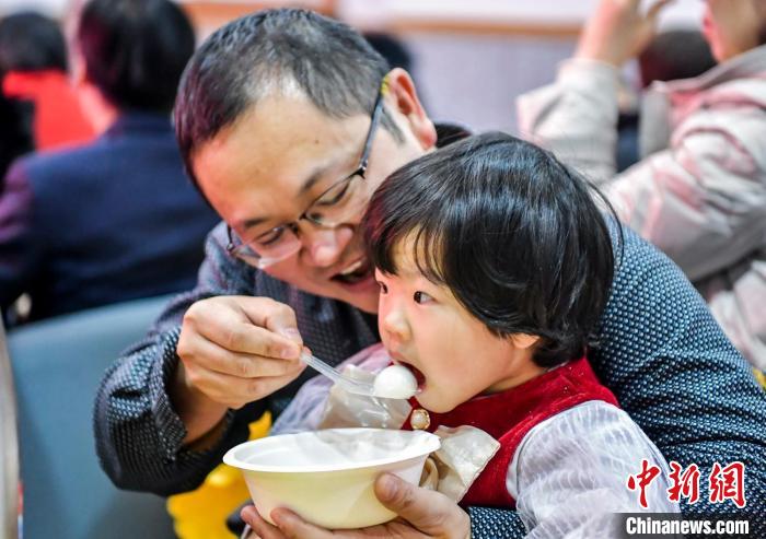 市民和孩子一起品嘗湯圓。　劉新 攝