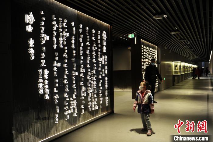 圖為孩童觀賞墻壁上的文字?！「咪?攝