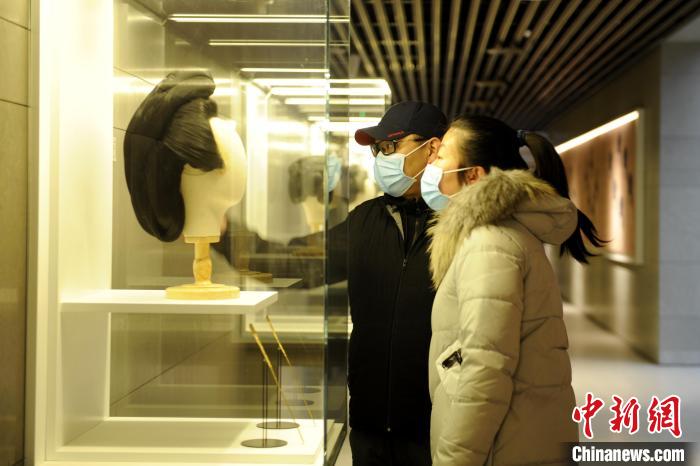圖為市民觀賞古人發(fā)型展品?！「咪?攝