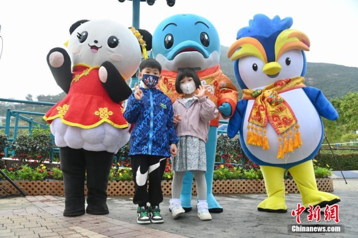 隨著香港與內(nèi)地全面“通關(guān)”，香港不少旅游活動重啟。2月11日上午，香港海洋公園迎來全面復(fù)常后的首個內(nèi)地點對點旅行團。該旅行團約有140名內(nèi)地旅客由深圳蓮塘口岸乘坐跨境專車直達香港海洋公園，園方特地為旅行團安排歡迎儀式，歡迎他們蒞臨香港海洋公園。圖為兒童與香港海洋公園吉祥物合影。李志華 攝