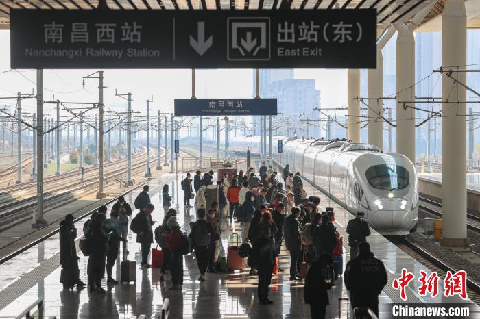 圖為江西南昌西站，一輛列車進站，旅客有序在站臺上候車?！⒘?攝