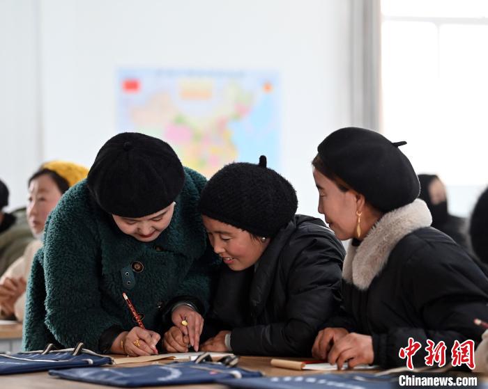 圖為甘肅廣河縣莊窠集鎮(zhèn)婦女，在老師指導(dǎo)下學(xué)習(xí)拼音。　九美旦增 攝