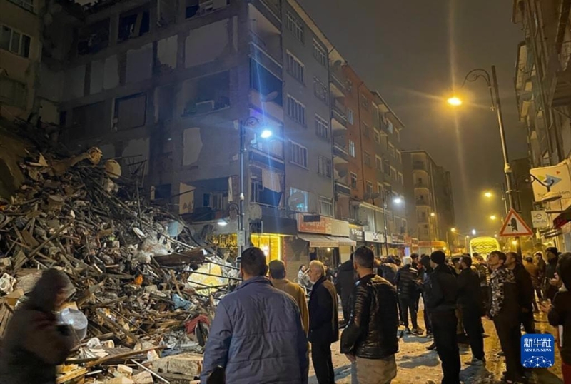 2月6日，在土耳其卡赫拉曼馬拉什省帕扎爾哲克，人們聚集在倒塌的建筑物旁。（圖源：新華社）