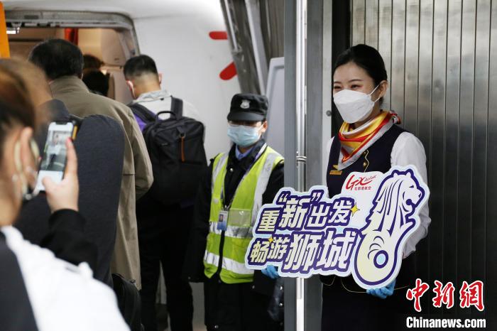 圖為北部灣航空乘務(wù)員在飛機(jī)艙門迎接旅客?！↑S秉柱 攝