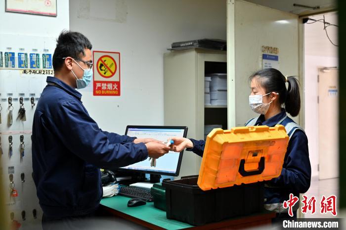 圖為咸俊領(lǐng)取工具?！∮峋?攝