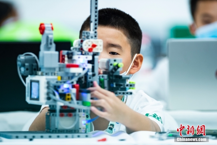 資料圖：一名參加青少年機(jī)器人設(shè)計(jì)大賽的小選手專注調(diào)試自己的機(jī)器人。 <a target='_blank' href='/'>中新社</a>記者 侯宇 攝