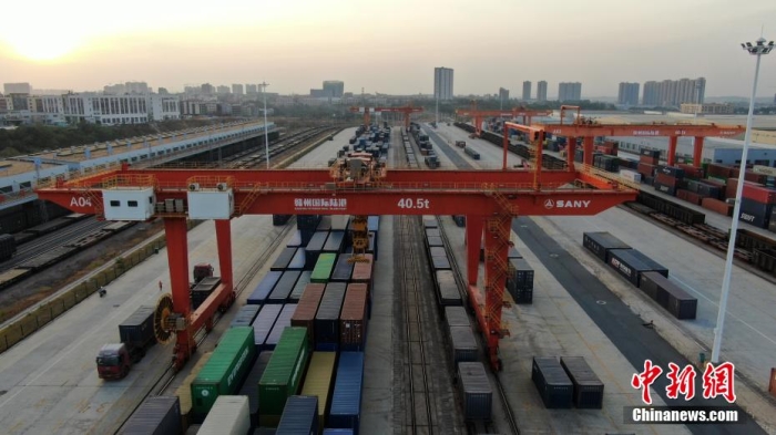 據(jù)了解，贛州國際陸港是全國第8個、也是全國革命老區(qū)唯一一個內(nèi)陸開放口岸，目前已開通5條鐵海聯(lián)運(yùn)“三同”班列線路，中歐(亞)班列線路覆蓋中亞5國和歐洲主要物流節(jié)點(diǎn)城市。圖為在夕陽映照下，巨大的龍門塔吊正在忙碌地裝運(yùn)各色集裝箱。姜濤 攝