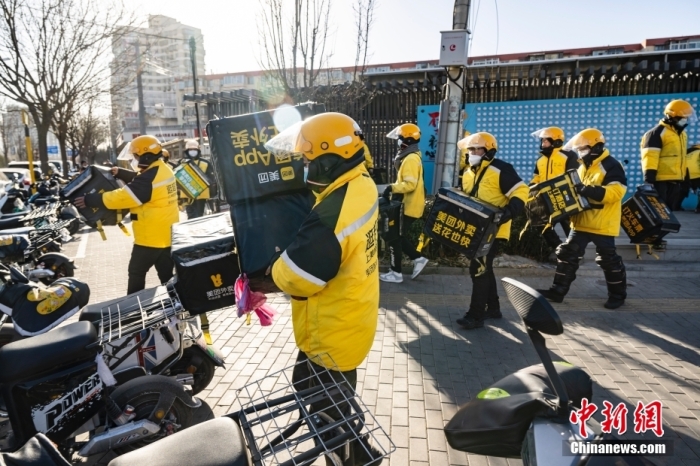 圖為外賣送餐員在北京市朝陽區(qū)的街頭開完早會后投入工作。 <a target='_blank' href='/'>中新社</a>記者 侯宇 攝