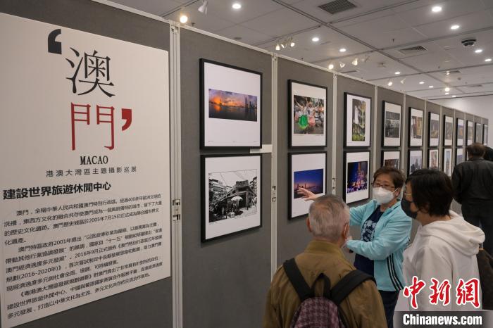 參觀者觀賞攝影聯(lián)展中有關(guān)澳門的圖片?！￡愑乐Z 攝
