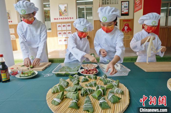 圖為鄭州小學(xué)生體驗包粽子。(資料圖) 韓章云 攝
