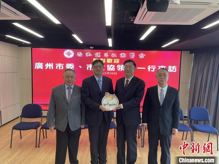 中共廣州市委常委、統(tǒng)戰(zhàn)部部長王世彤(右二)向香港僑界社團(tuán)聯(lián)會會長黃楚基(左二)致送紀(jì)念品。　香港僑界社團(tuán)聯(lián)會供圖