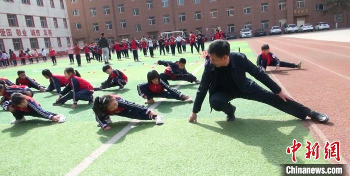 圖為“校長爺爺”與學(xué)生們一起運動。　陳峰 攝