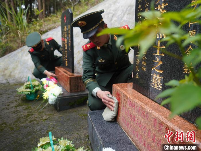 武警官兵為烈士擦去碑前塵土?！∈Y蘇昇 攝