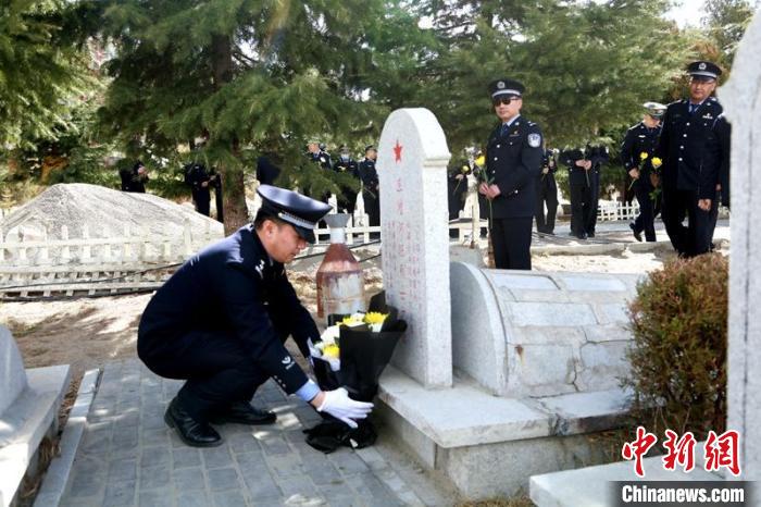 圖為西藏邊檢總站執(zhí)法調(diào)查支隊(duì)民警為旦增阿旺烈士擦拭墓碑、敬獻(xiàn)鮮花?！⒚麝?攝
