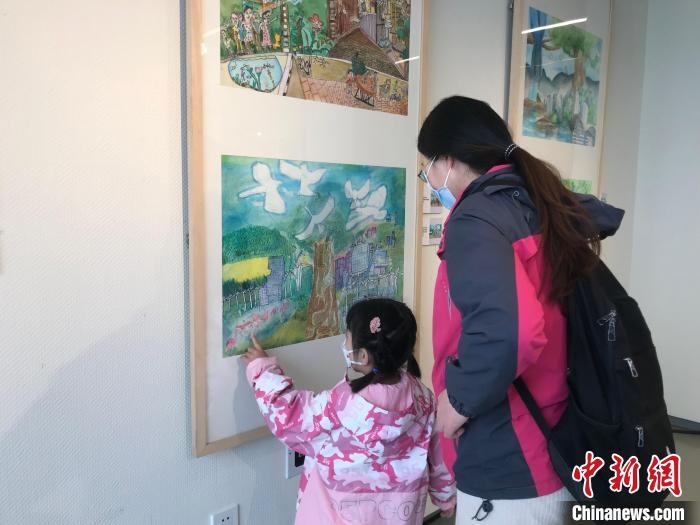 4月9日，“大灣區(qū)孩子們心目中的碳中和世界”繪畫作品展開幕。圖為民眾在展品前駐足觀賞?！￡惤ㄐ?攝