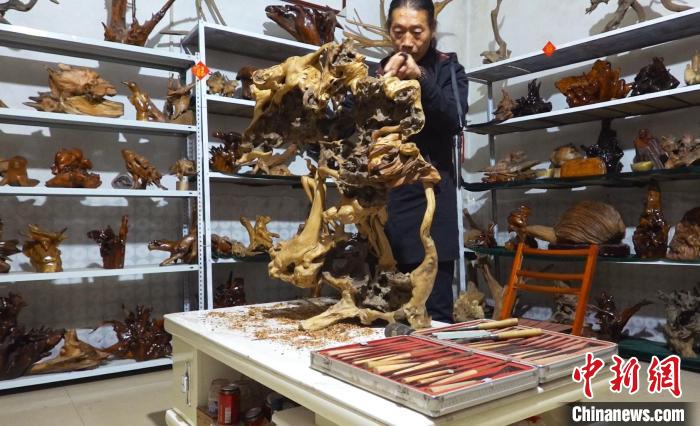 唐永懷正在雕刻作品《國色天香》?！∶系澱?攝