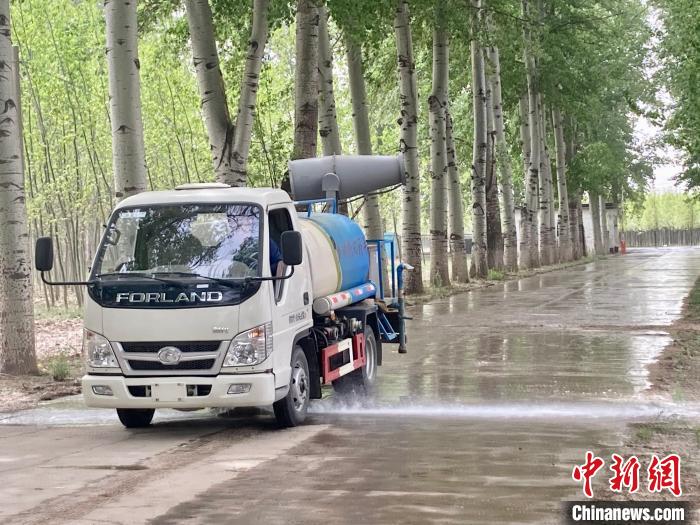 圖為灑水車在對地面進行濕化，降低飄絮強度?！⌒戽?攝