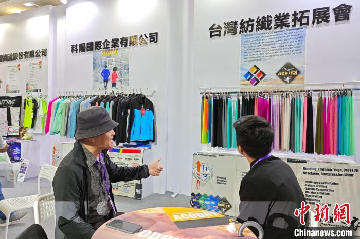 臺商邱鶴銘(左)在展位上介紹新研發(fā)的功能面料。　吳冠標 攝