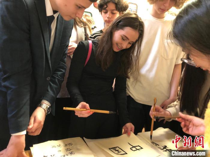 4月21日，莫斯科國立語言大學(xué)孔子學(xué)院附屬中學(xué)舉辦“國際中文日”活動，學(xué)生們學(xué)寫漢字?！∧箍茋⒄Z言大學(xué)孔子學(xué)院 供圖