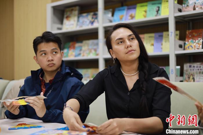 留學(xué)生們正在動(dòng)手制作中國(guó)傳統(tǒng)玩具?！⌒吕俪霭嫔绻﹫D