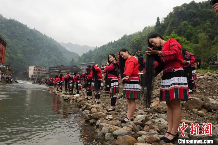 4月22日，在廣西龍勝各族自治縣龍脊鎮(zhèn)黃洛瑤寨，當(dāng)?shù)噩幾迕癖娫诤舆呴_展長發(fā)梳妝表演。　韋吉陽 攝