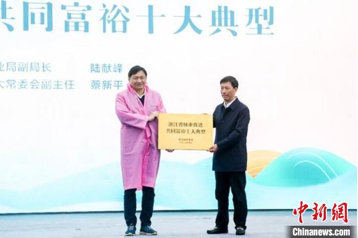 浙江省林業(yè)局副局長陸獻(xiàn)峰(左)為浙江省林業(yè)推進(jìn)共同富裕十大典型授牌現(xiàn)場?！”P峰鄉(xiāng)人民政府 供圖