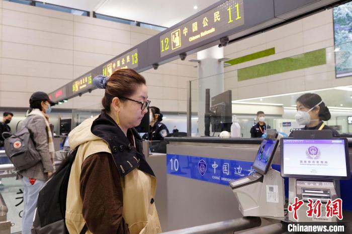 虹橋邊檢站民警在對出境旅客進行信息核查。　殷立勤 攝