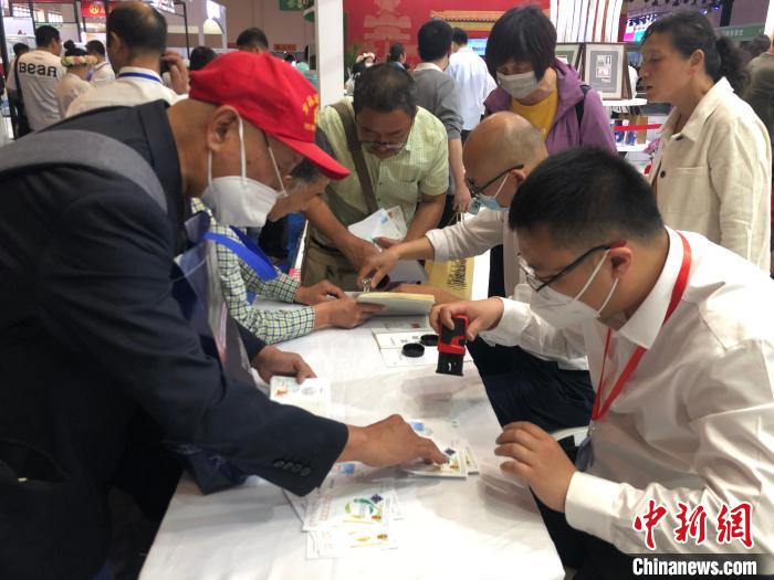 圖為集郵愛好者在現(xiàn)場加蓋郵戳。　葉娜 攝