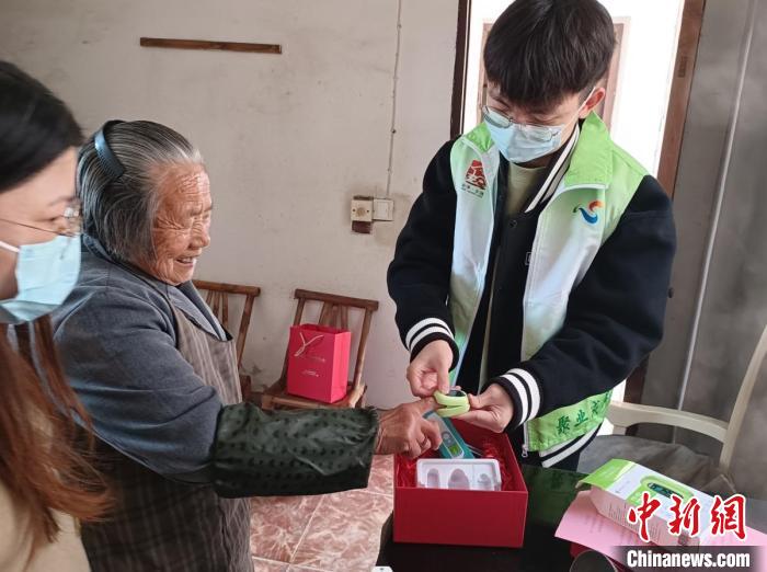 指導(dǎo)僑界老人使用血氧儀?！＄娦?攝