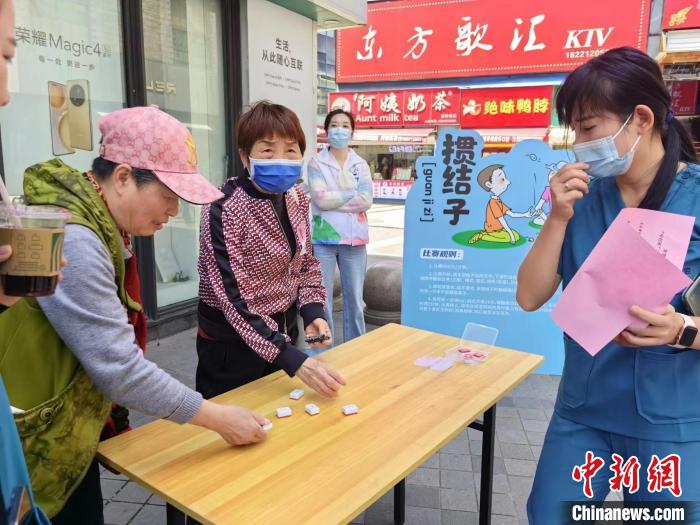 阿姨們熟練地玩起“摜結(jié)子”?！≠Z宇巍 攝