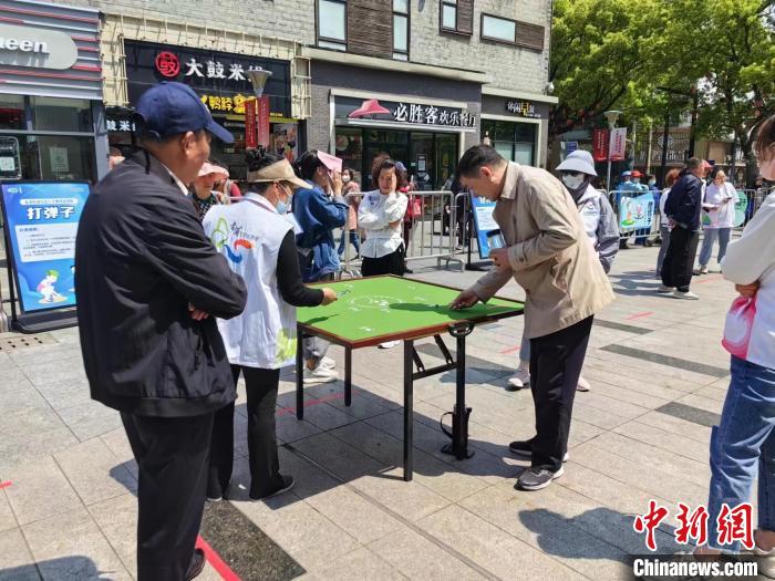 伯伯們開心地打彈子。　賈宇巍 攝