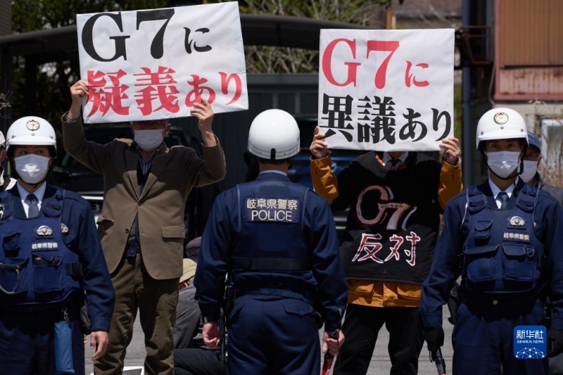 4月16日，在日本長野縣輕井澤車站附近，抗議者手舉標語抗議。（圖源：新華社）