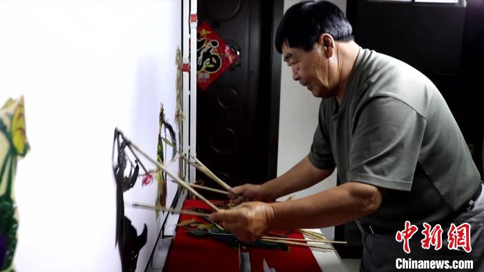圖為馮克獻(xiàn)進(jìn)行皮影表演?！●R瑾 攝