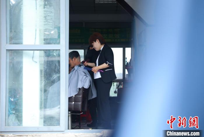 周麗麗正在給客人理發(fā)?！￡惣覙?攝