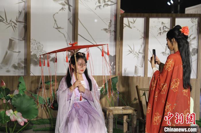 圖為市民游客在?？诠棚L(fēng)市集體驗(yàn)漢服，拍照打卡?！?jiān)潞?攝