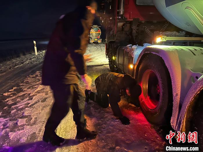 圖為民警幫助受困車輛安裝防滑鏈?！」逯菸麄鞑抗﹫D