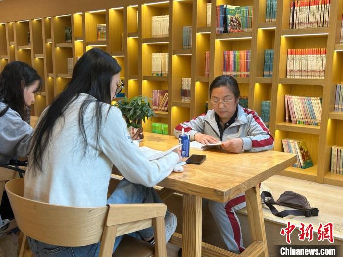 圖為22日，左桂香(右一)在新建區(qū)抱樸書屋閱讀?！≈飕?攝