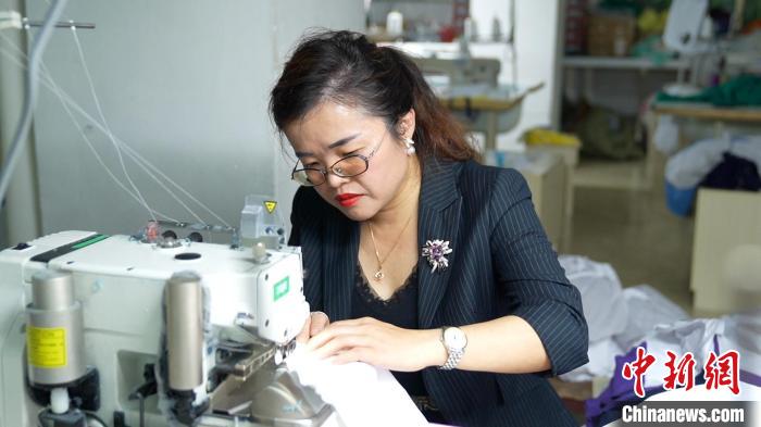 圖為李王花上機操作縫紉服裝?！￡愑⑶?攝