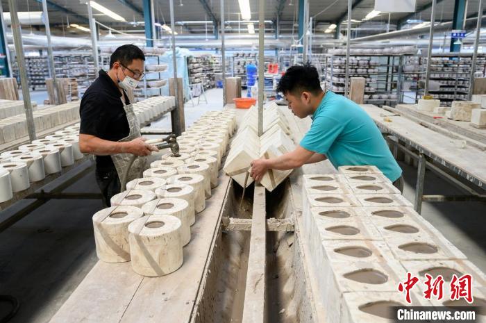 劉上輝正和工人趕制一批銷往俄羅斯、土耳其等國家的手工陶瓷產(chǎn)品?！№f亮 攝