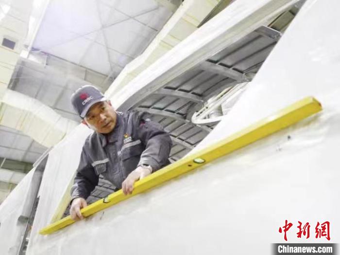 周晶輝正在測量車體外形平度。　受訪者供圖