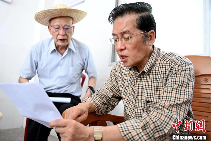 張榮恭(右)在詔安縣秀篆鎮(zhèn)北坑村與族親比對(duì)族譜?！埥鸫?攝