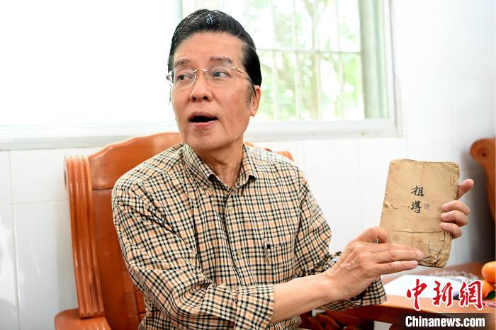 張榮恭手中拿著北坑村族親收藏的族譜與族親交流?！埥鸫?攝