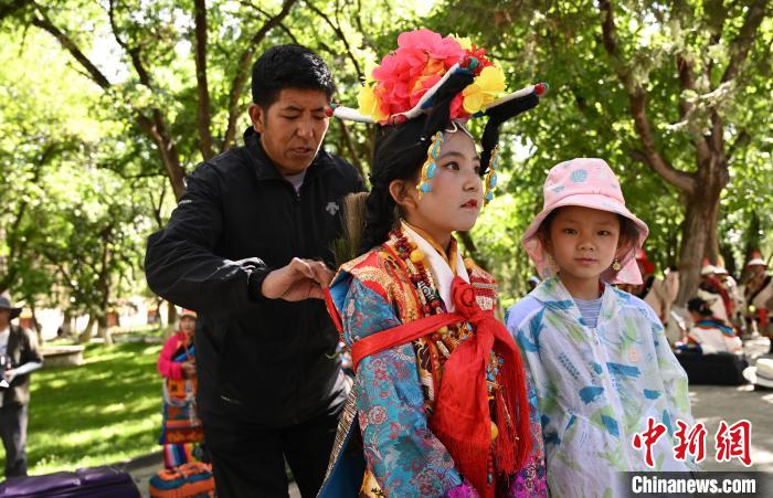 圖為上臺前，其美卓嘎的父親為她整理演出服?！≮w朗 攝