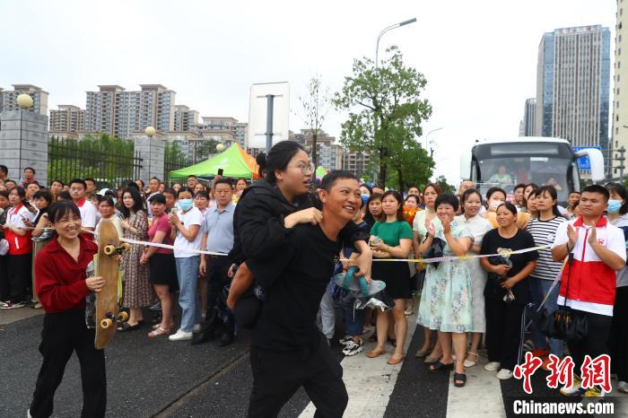 圖為蔣張子怡的父親背著她往外走，母親拿著女兒的滑板跟在后面。　劉占昆 攝