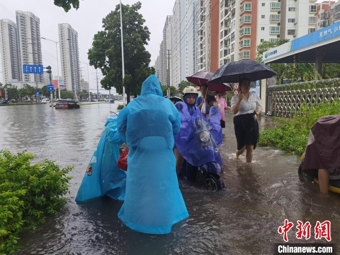 6月8日，強(qiáng)降雨過后，北海市民涉水出行?！〉岳顝?qiáng) 攝