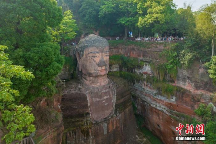 遠(yuǎn)眺樂(lè)山大佛，旁邊佛頭觀景平臺(tái)擠滿了游客。劉忠俊 攝