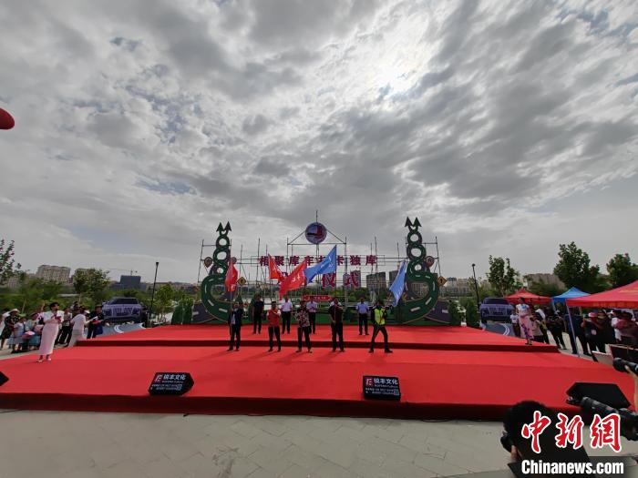 發(fā)車(chē)儀式上，與會(huì)嘉賓為摩托車(chē)隊(duì)、房車(chē)等代表授旗。　王小軍 攝